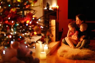 Mutter mit Kindern vom Kamin Weihnachten